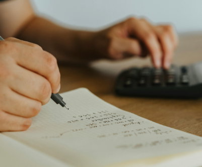 photo of a hand writing with a black pen